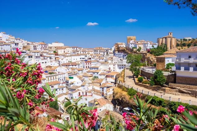 8. Setenil de las Bodegas, Cádiz. Es una de las localidades más singulares de los Pueblos Blancos de la Sierra de Cádiz. Las casas se sitúan a diferentes niveles, unas bajo la roca y otras sobre ella, creando calles-cueva, miradores y rincones de una belleza extraordinaria. Es de origen medieval, conservándose a día de hoy vestigios de su pasado almohade en el espacio de La Villa, aunque la presencia humana data desde el neolítico. De la fortaleza medieval se mantiene en pie la Torre del Homenaje y un aljibe subterráneo. Además, su patrimonio se completa con la Iglesia Parroquial de Nuestra Señora de la Encarnación, de estilo tardo-gótico renacentista, y las ermitas de Nuestra Señora del Carmen, San Benito y San Sebastián. La Antigua Casa Consistorial posee un magnifico artesonado mudéjar del siglo XVI, único en la provincia, y su visita se inscribe en la llamada Ruta de los Reyes Católicos, un recorrido que permite conocer el legado histórico de Setenil ligado a la conquista cristiana en 1484. Asimismo, en el municipio se inscribe una amplia oferta de senderos y rutas en las que disfrutar de su privilegiado entorno.