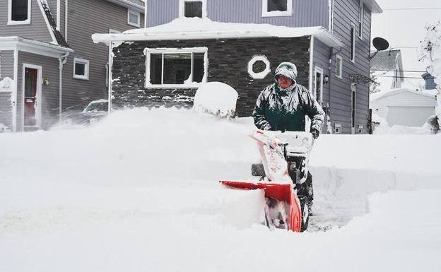 A man removes snow left behind by the storm that affected much of the United States in December 2022 