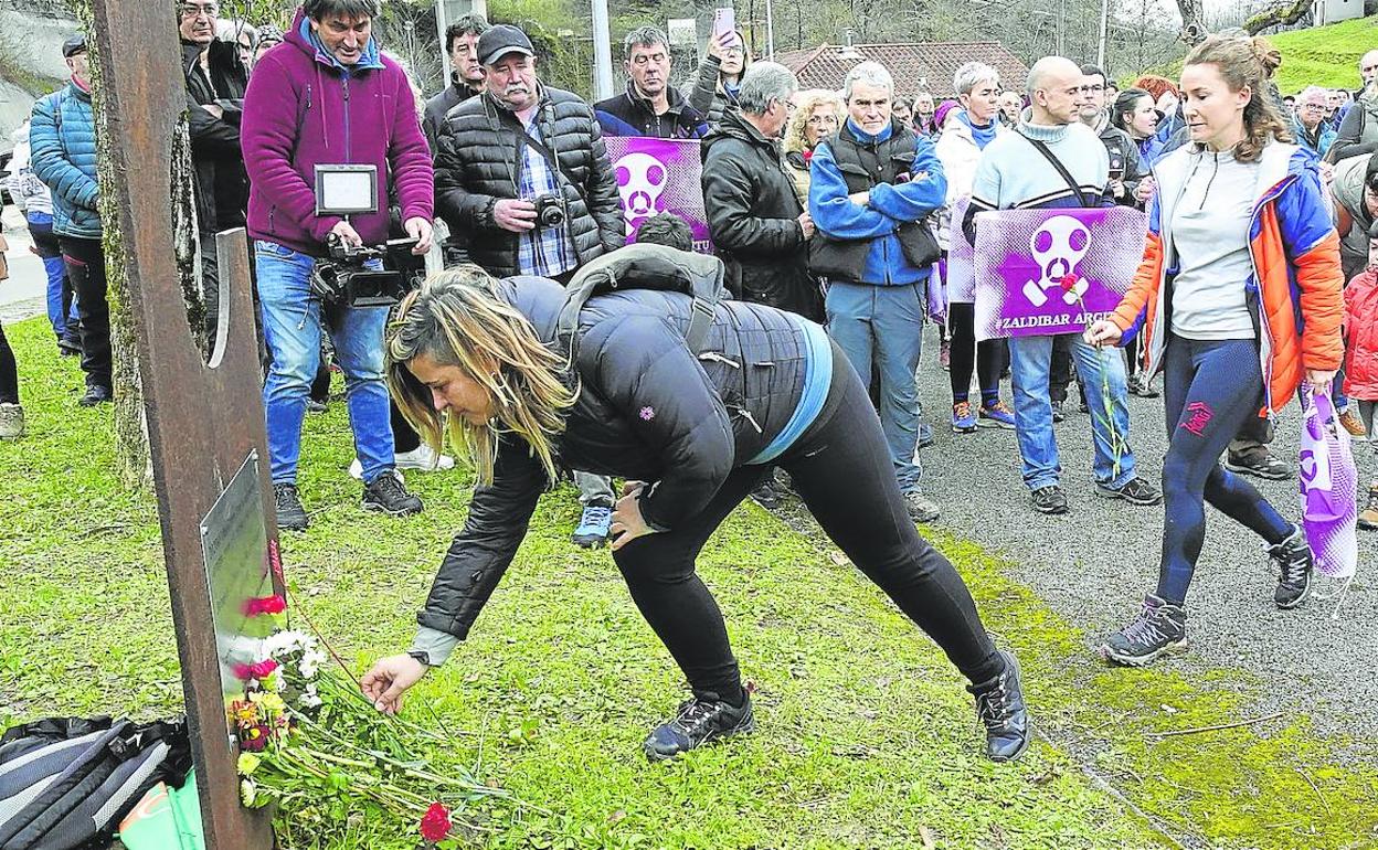 Los participantes en el homenaje de ayer realizan una ofrenda foral en la escultura colocada junto al vertedero en recuerdo de las dos víctimas del derrumbe.