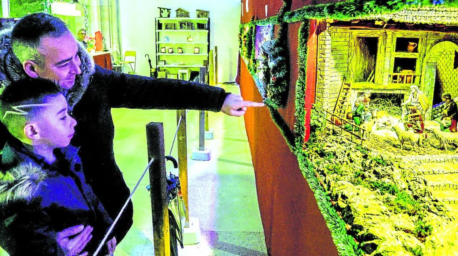 Dos visitantes disfrutan de uno de los belenes expuestos en la Iglesia de la Encarnación.