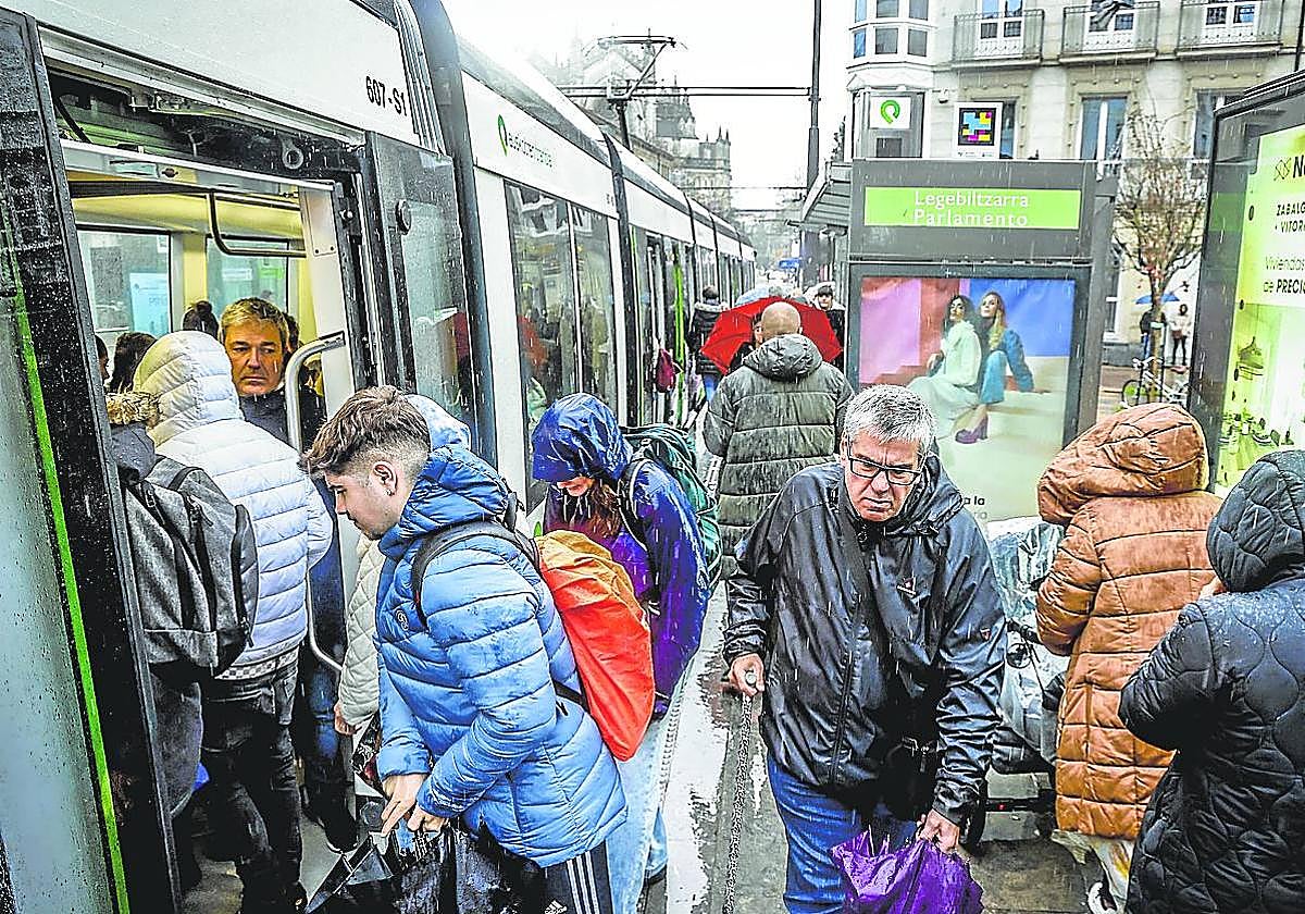 Viajeros entran en el tranvía a su paso por la parada de Parlamento.