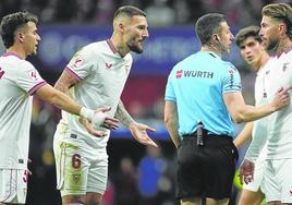 Sergio Ramos atiende las indicaciones del colegiado tras protestar una acción en el duelo liguero contra el Atlético.