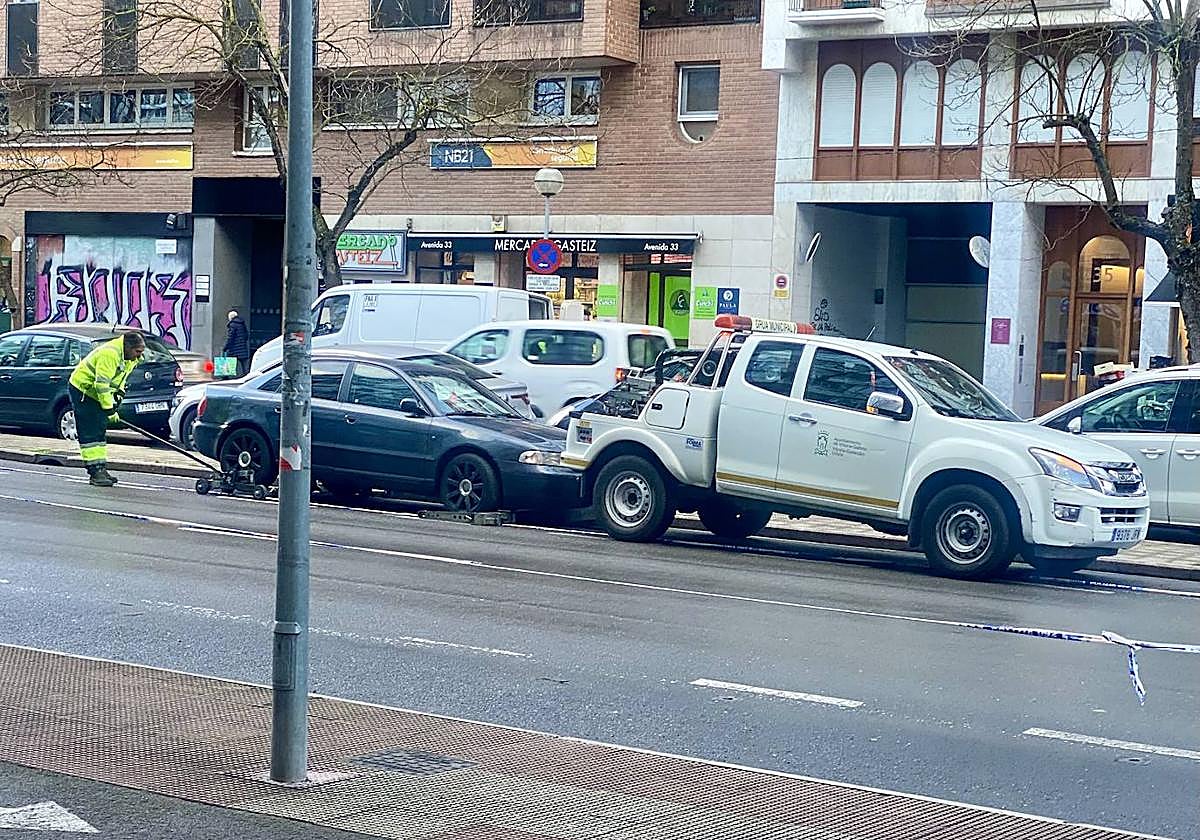 Un operario retira un vehículo mal estacionado en la Avenida de Gasteiz esta mañana de viernes.