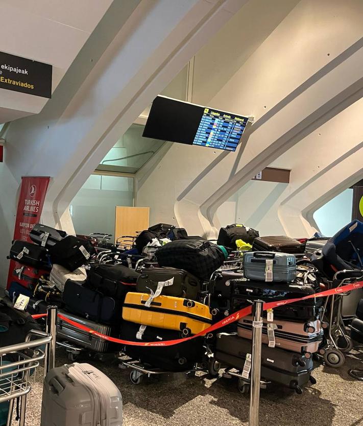 Imagen secundaria 2 - Estampas de este viernes en el aeropuerto de Loiu, donde se han formado larguísimas colas a lo largo de la mañana que prácticamente salen por la puerta de acceso a la terminal. Las maletas se amontonan en la zona de recogida