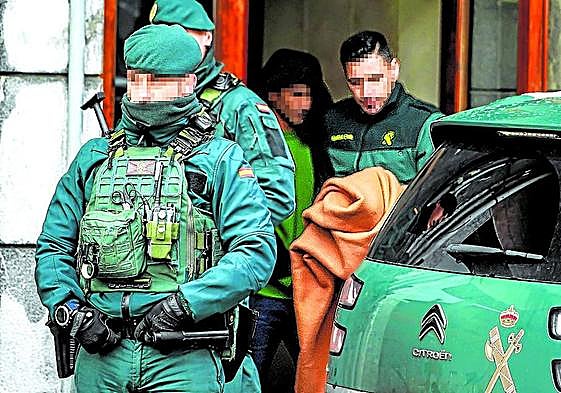 Agentes de la Guardia Civil con el detenido hoy en Romo, tras finalizar el registro de la vivienda.