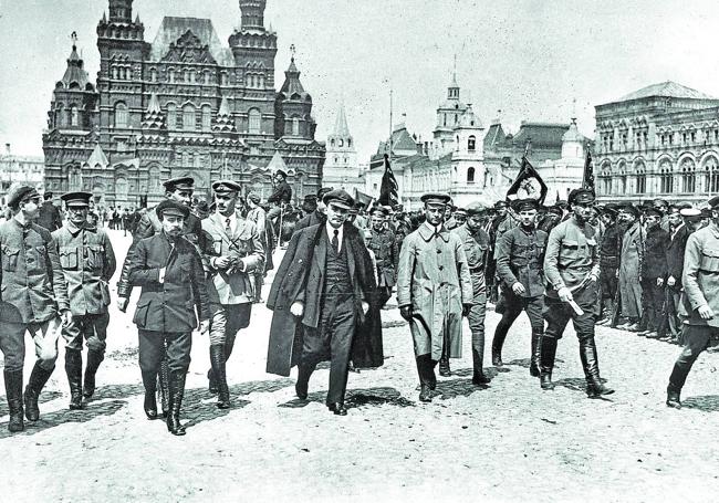 Con un grupo de jefes militares en la Plaza Roja de Moscú en 1919. Abajo, disfrazado de fogonero para pasar a Finlandia en 1917.