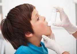 Una enfermera enseña a un niño a usar un inhalador.