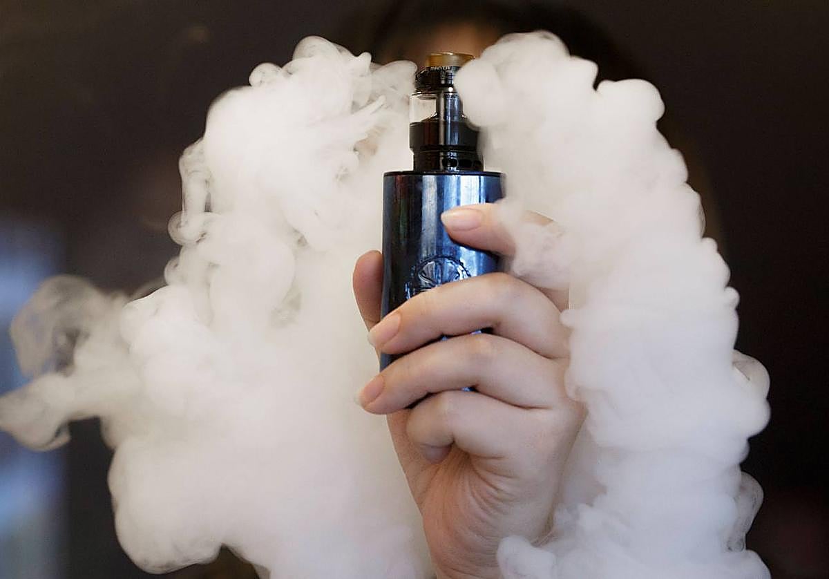 Una vendedora sujeta un cigarrillo electrónico.