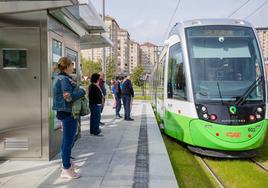 Viajeros esperan al tranvía a su paso por el barrio de Santa Lucía.