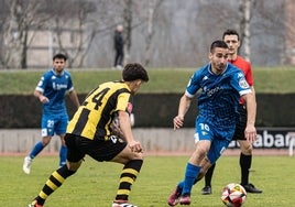 Yeray Cuello conduce el balón ante la oposición de Arredondo.