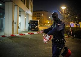 Un ertzaina retira la cinta de seguridad tras finalizar el operativo en la calle Helsinki.