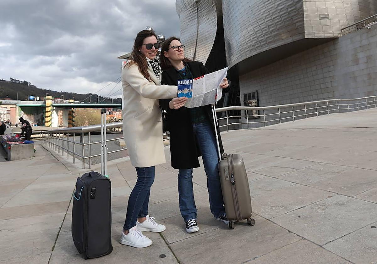 Dos turistas consultan un plano junto al Guggenheim.