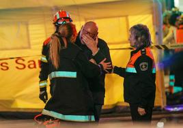 Vecinos y policía atienden a un vecino el día de la tragedia.