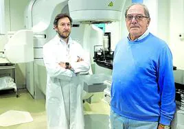 Alfonso Gómez Iturriaga y su paciente Juan José Loredo junto a un acelerador lineal.