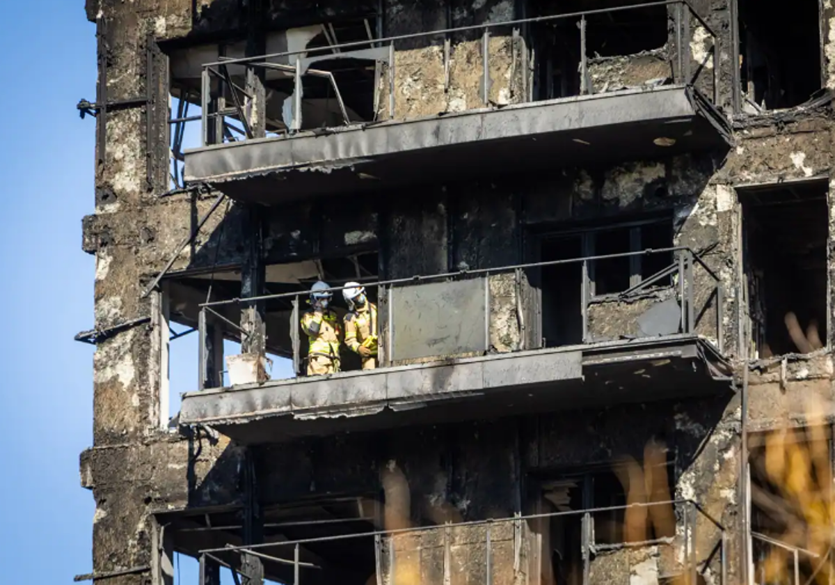 Dos bomberos inspeccionan una de las viviendas arrasadas por el fuego.