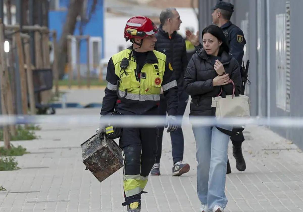 Un bombero acompaña a una vecina con sus pertenencias.