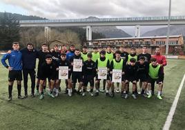 Los jóvenes futbolistas posan con el cartel para recaudar fondos.