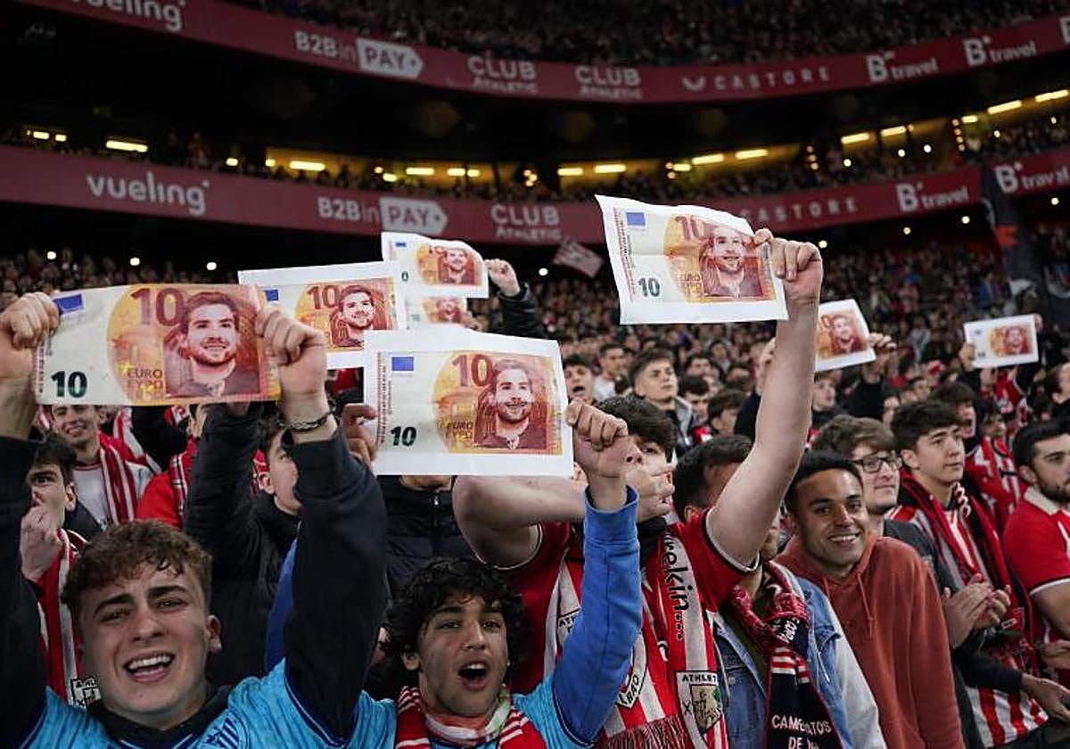 Varios hinchas del Athletic muestran billetes con la cara de Iñigo Martínez