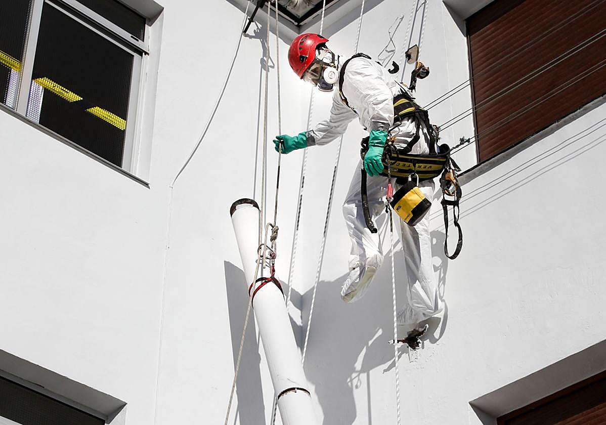 Dos operarios ajenos a la información realizan labores con amianto.