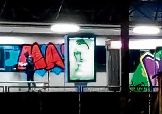 Un grupo de grafiteros pinta un vagón de metro en la estación de Ibarbengoa en Getxo.