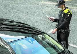 Un Policía Local multa a un conductor en una calle de Vitoria.