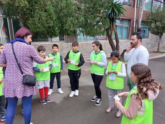 Una profesora del colegio público de Romo entrega los talones de multas cívicas a los alumnos.