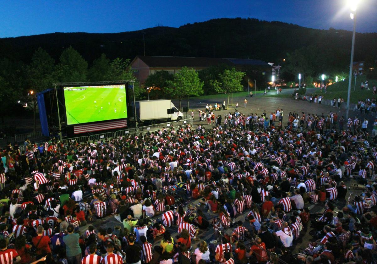 Aficionados del Athletic presencian un partido en una pantalla gigante.