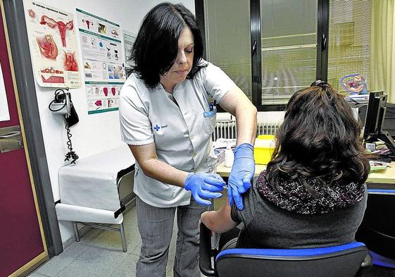 Una mujer embarazada recibe una vacuna contra la tosferina en un centro asistencial.