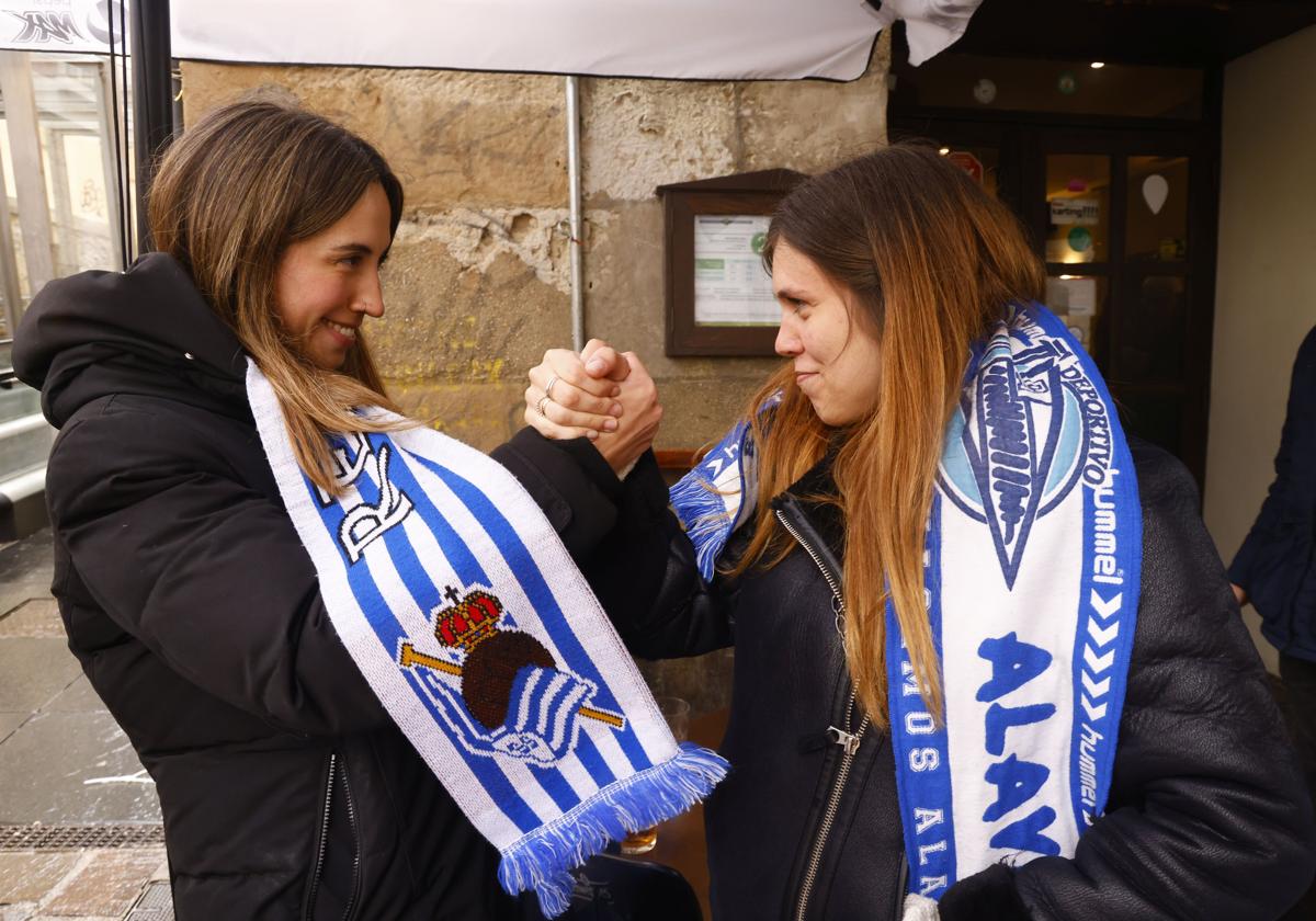 Una aficionada del Alavés y otra de la Real Sociedad echan un pulso en las horas previas al derbi.