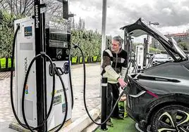 Un conductor recarga su coche eléctrico en un punto público situado en una calle de Vitoria.