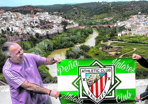 Rafael Madueño y Tomás Joven sostienen el escudo de su peña rojiblanca con el pueblo de Montoro completando la escena.
