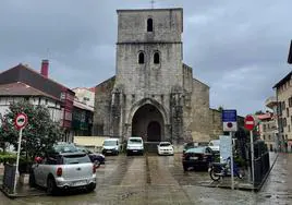 Varios coches aparcados en la plaza de la iglesia Santa María Magdalena en Plentzia.