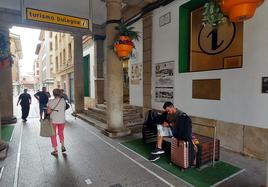 Un turista consulta una guía a las puertas de la Oficina de Tursimo de Gernika.
