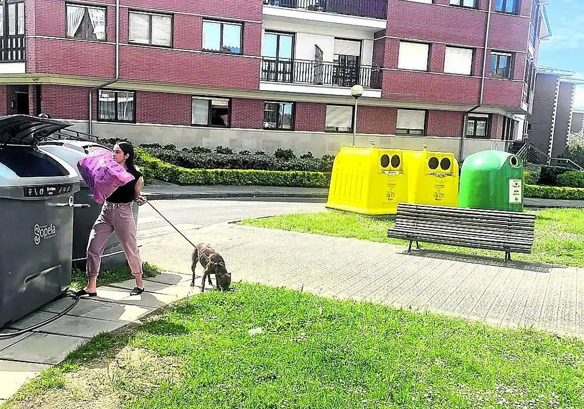 Una vecina de Sopela pasea a su perro en uno de los jardines.