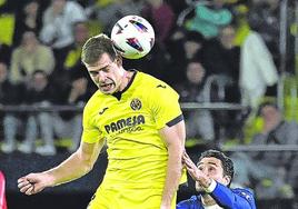 El delantero del Villarreal Sorloth pelea un balón aéreo vigilado por el central del Atlético José María Giménez.