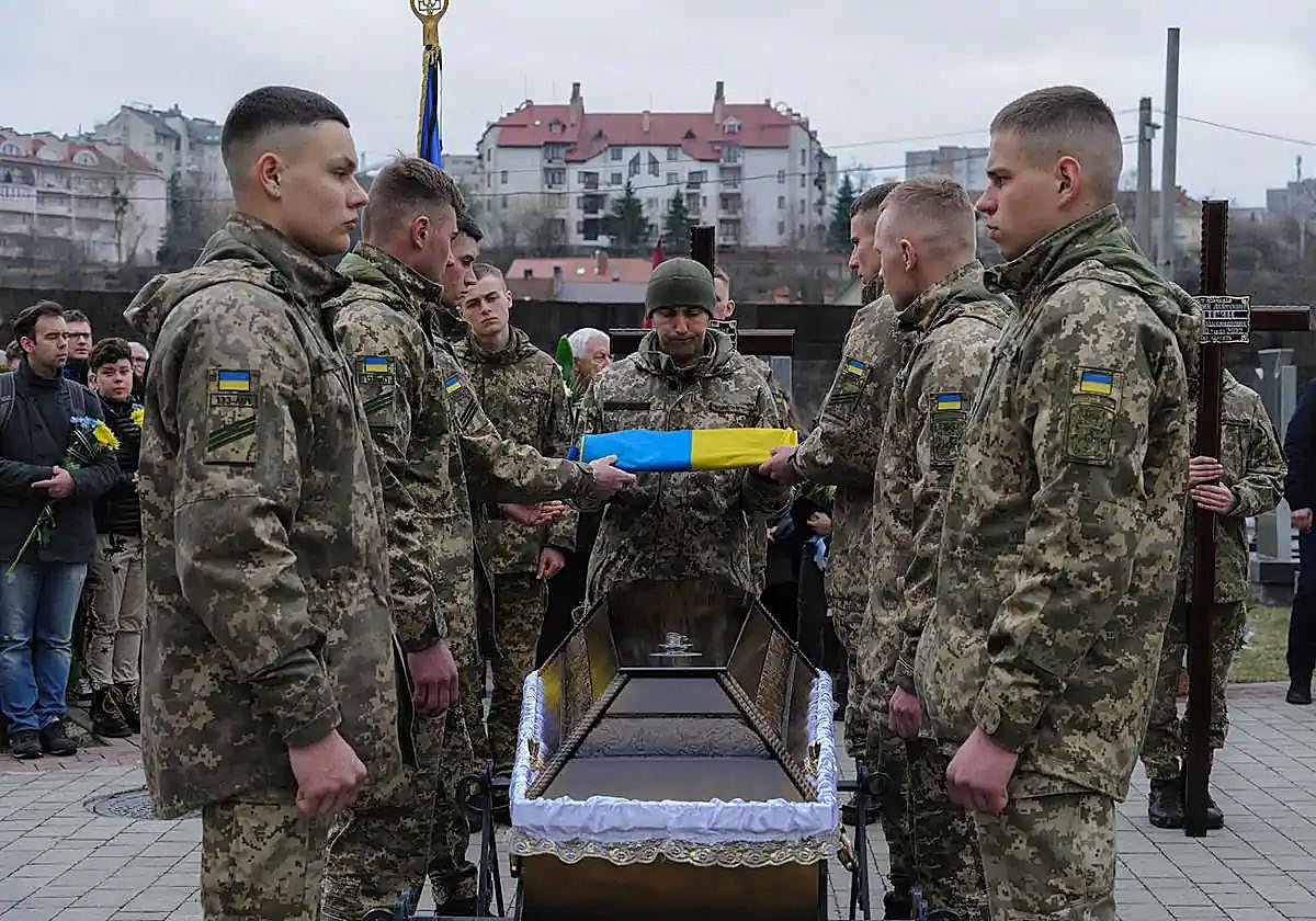 Soldados ucranianos realizan un homenaje al cadáver de un compañero entregado por Rusia.