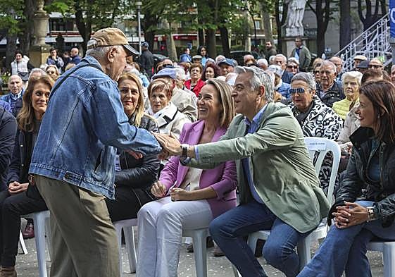 Un asistente al mitin en Vitoria saluda al candidato a lehendakari del PP, Javier de Andrés, en presencia de Cuca Gamarra.