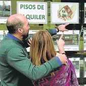 Una pareja consulta los precios del alquiler de viviendas en una inmobiliaria en el centro de Bilbao.