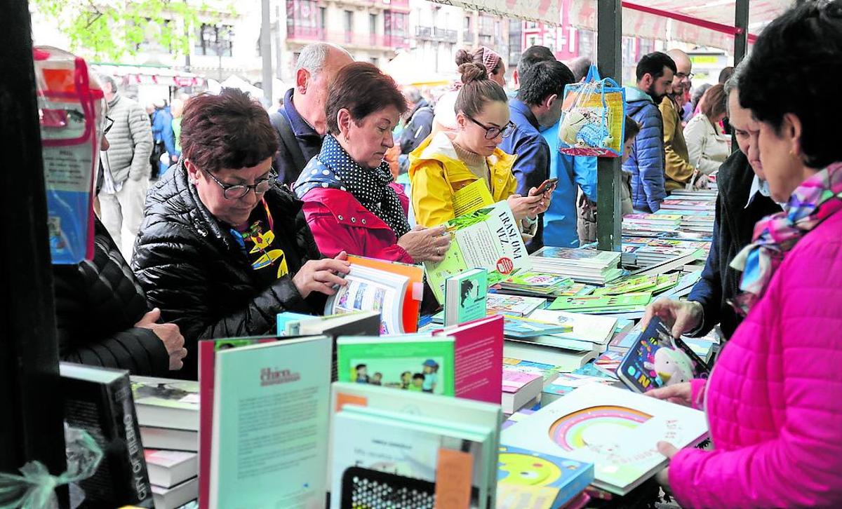 Varias lectoras hojean los libros de uno de los puestos, en una de las ediciones anteriores del Día.