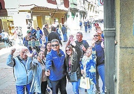 Turistas de Puerto Rico se hacen un selfie junto al portal de una vivienda turística en el Casco Viejo de Bilbao.