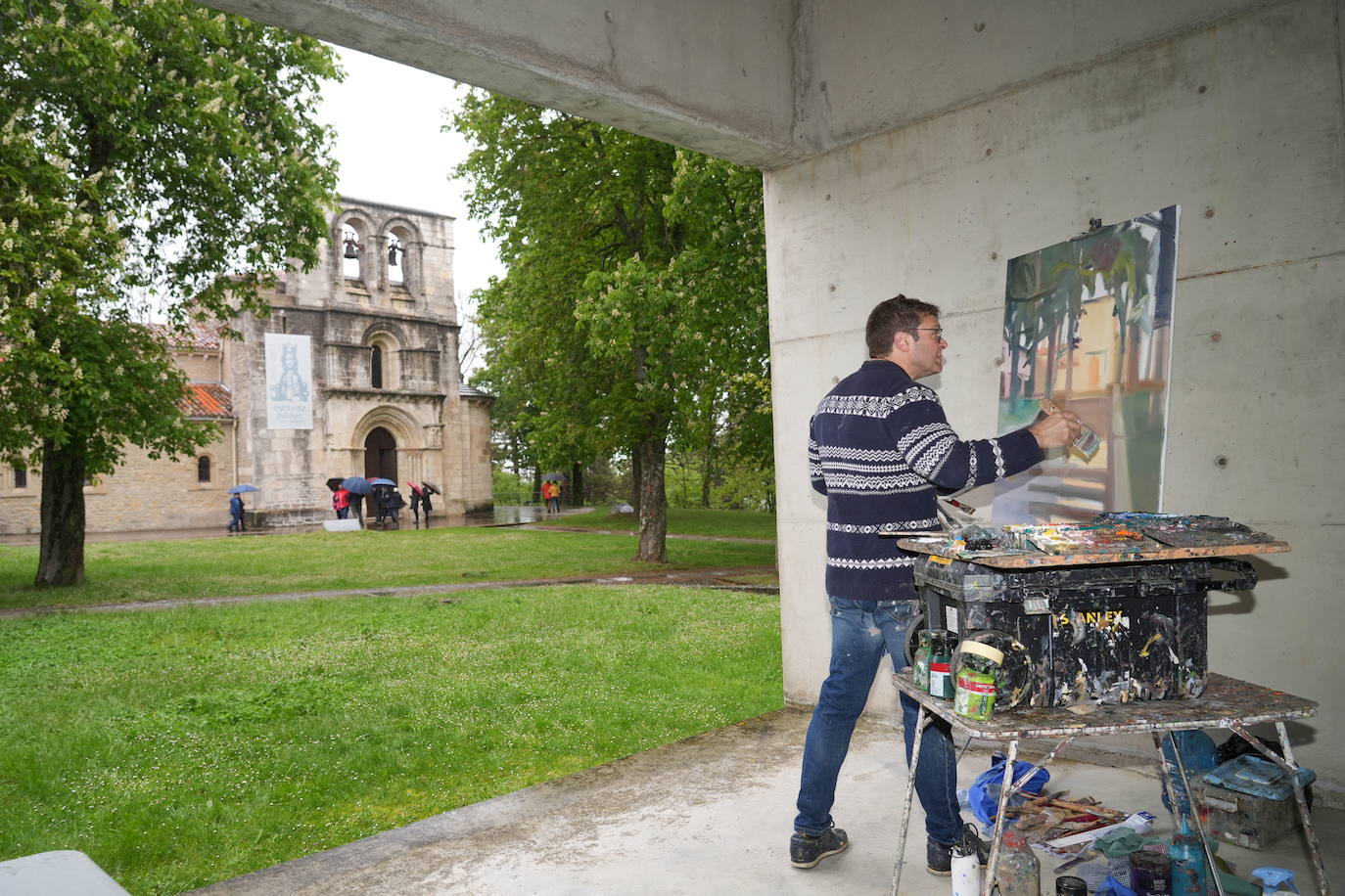 Los participantes del concurso de pintura al aire libre se resguardan.