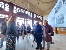 La comisaría María José Villa explica a los integrantes de la coporación municipal los detalles de la muestra.