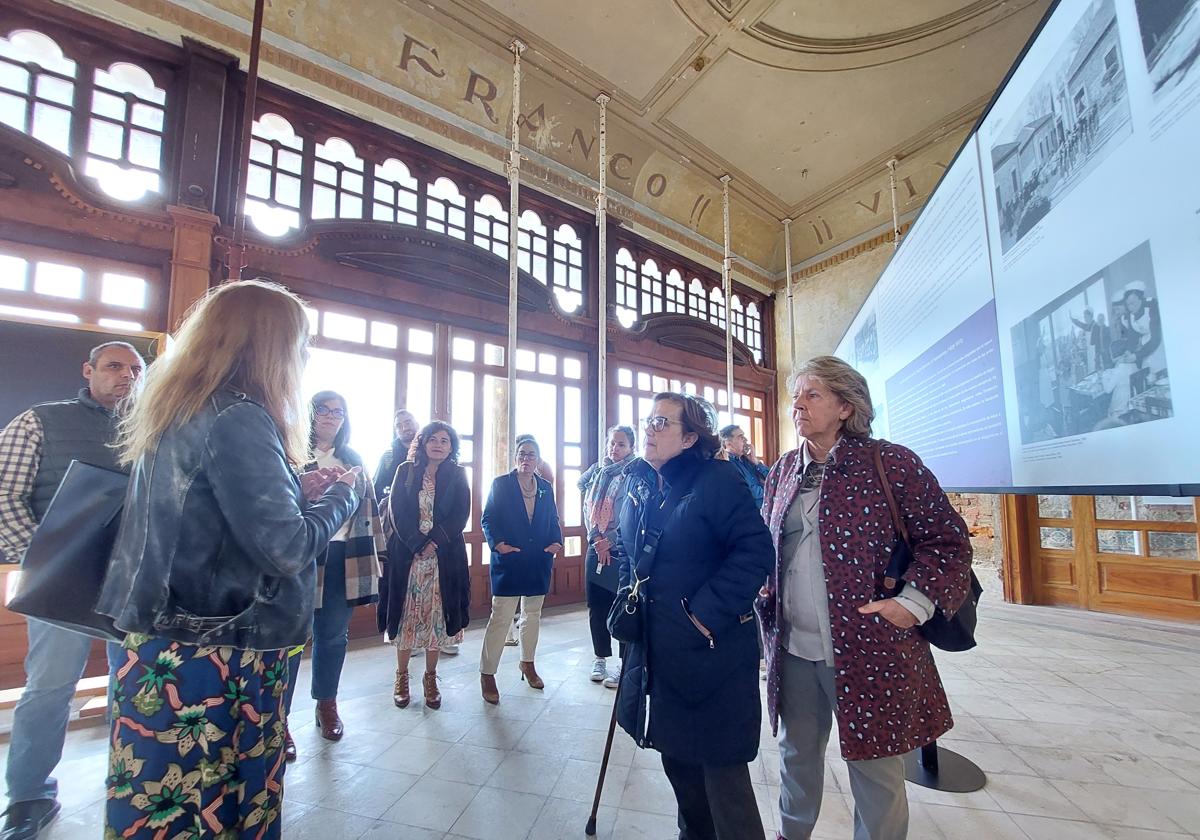 La comisaría María José Villa explica a los integrantes de la coporación municipal los detalles de la muestra.