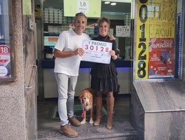 Jon Idirin y Nora Calzada, propietarios de la administración de lotería 'Los Millones' con el cartel del Gordo del Sorteo Extraordinario del Día de la Madre.