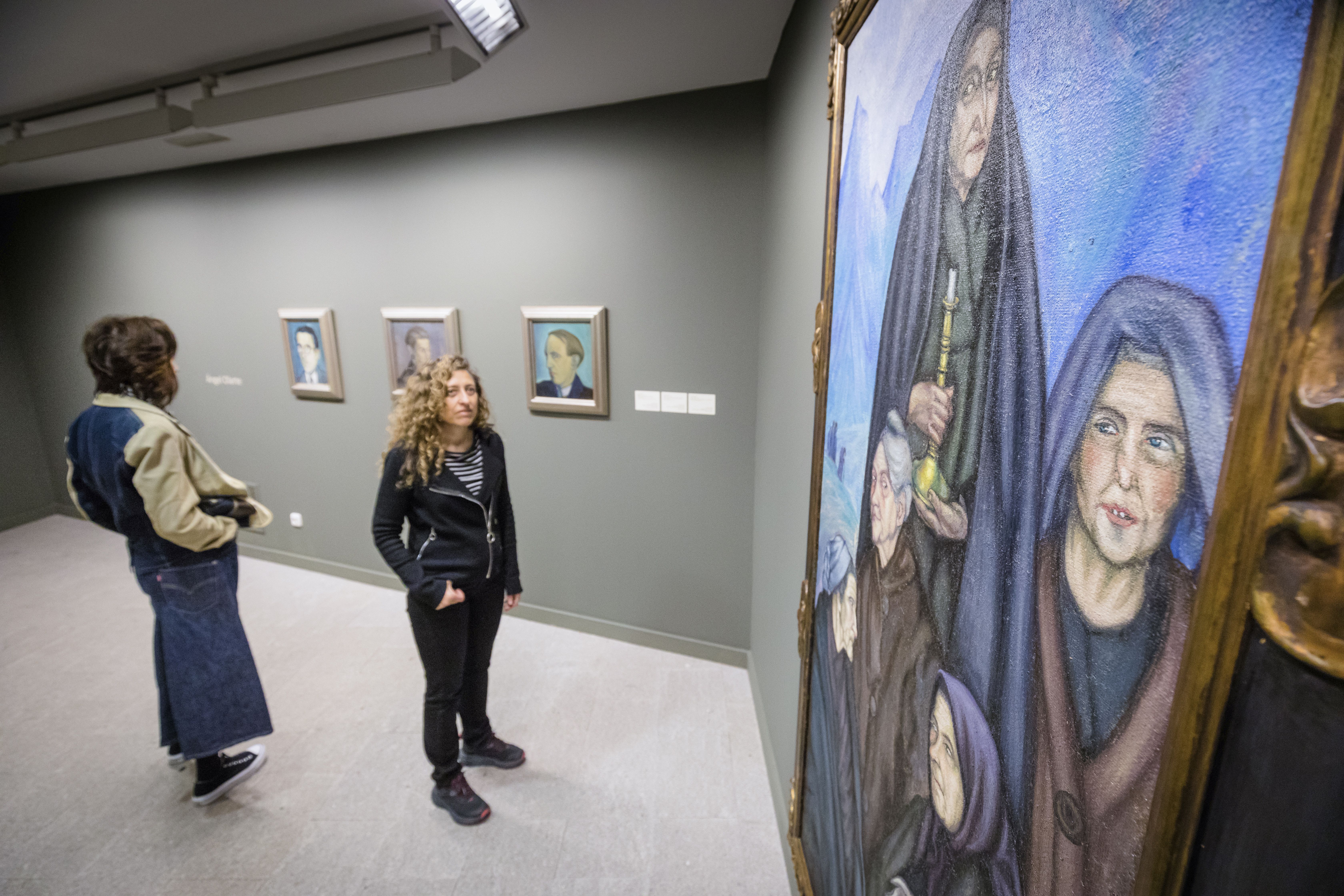 Dos espectadores en la sala dedicada al pintor vitoriano Ángel Olarte. 