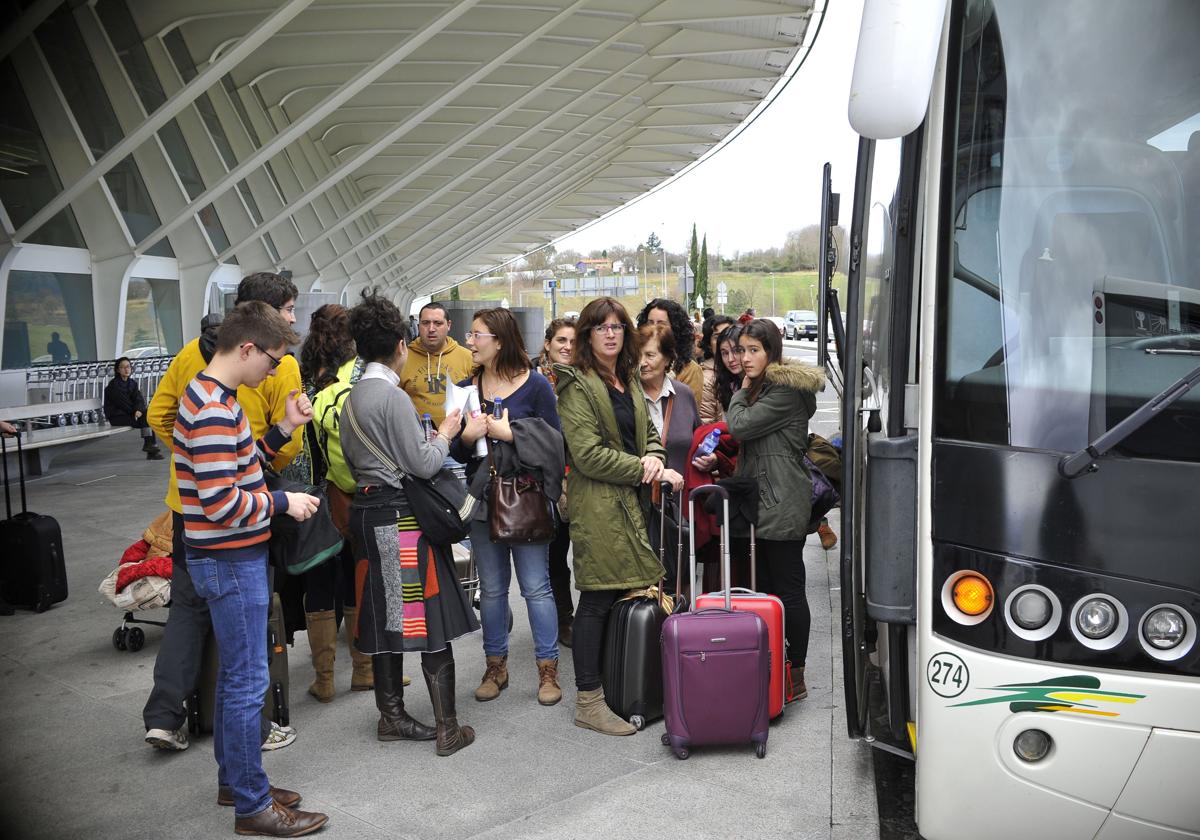 Un grupo de viajeros espera a subirse a un autobús en el aeropuerto de Loiu