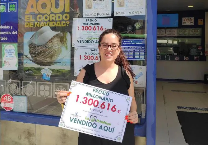 Ariana Diaz, head of the Ortuella Lottery Authority No. 1, poses happily with a poster of a big prize.