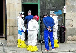 Agentes de la Policía Científica de la Ertzaintza recogen pruebas en la lonja incendiada en Atxuri.