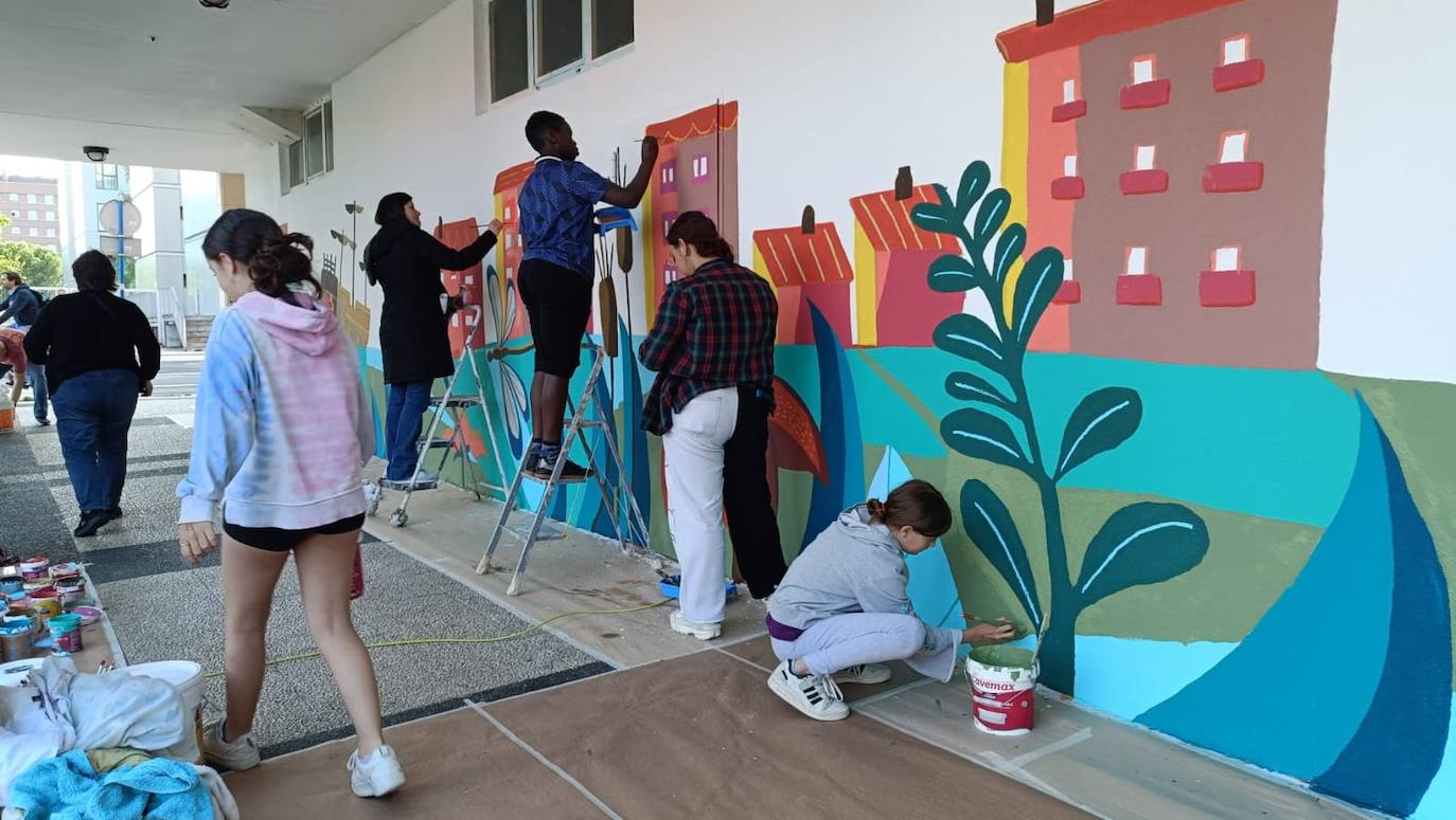 En imágenes: 150 vecinos de Ibaiondo pintan un mural de 24 metros