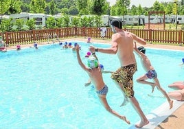 Una familia disfruta de la piscina del camping de Angosto.